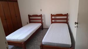 two beds sitting next to each other in a room at Residencial requinte in Bragança Paulista
