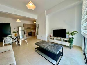 a living room with a couch and a tv at 1 bedroom flat next to university in Aglantzia