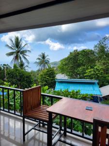 a balcony with a wooden bench and a table at Marine House Koh Tao in Koh Tao
