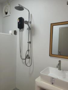 a shower in a bathroom with a sink and a mirror at Marine House Koh Tao in Koh Tao