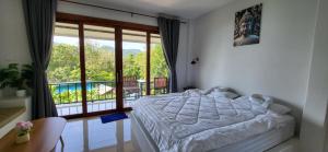 a bedroom with a bed and a balcony at Marine House Koh Tao in Koh Tao