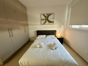a bedroom with a white bed with towels on it at 1 bedroom flat next to university in Aglantzia
