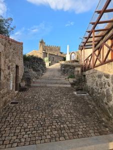 a cobblestone street with a castle in the background at Casa do castelo in Penamacor +7 photos