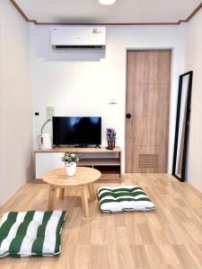 a living room with a table and a tv at Our Time Staycation in Ban Chak Makham