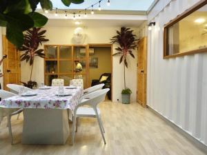 a dining room with a table and white chairs at Our Time Staycation in Ban Chak Makham