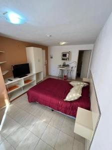 a bedroom with a bed with a red bedspread at Complejo miligamapa in Villa Carlos Paz +34 photos