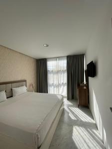 um quarto com uma grande cama branca e uma janela em Marina sweet em Tânger