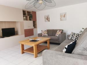Una sala de estar con un sofá y una mesa de café. en Ty Coz Hermine, en Riec-sur-Bélon