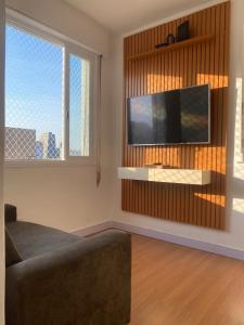 a living room with a couch and a flat screen tv at Apê 126 - Vista Mar in São Vicente