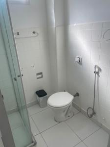 a white bathroom with a toilet and a shower at Apê 126 - Vista Mar in São Vicente +3 photos