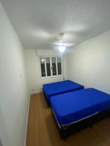 a small room with two blue beds in it at Apê 126 - Vista Mar in São Vicente