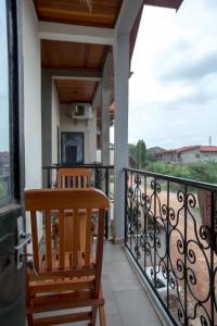 - Balcón con mesa de madera y silla en Appartement 3 chambres à Mimboman Maetur, en Yaoundé