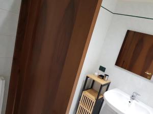 a bathroom with a sink and a wooden door at Appartamento Otelia in Cremona +25 photos