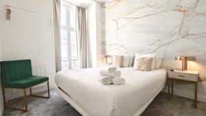 una camera con un letto bianco e una sedia verde di Lisbon Studios a Lisbona
