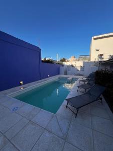 拉斯格路塔斯Summer的建筑物旁边有躺椅的游泳池