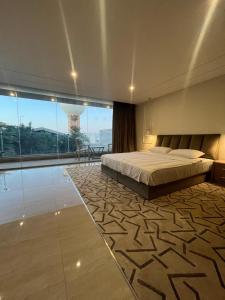 a bedroom with a bed and a view of a tower at شاليه الإطلالة فخم ووسط الرس in Al Rass