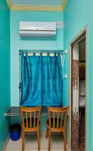 two chairs in a room with a blue wall at Deb Guest House 2 