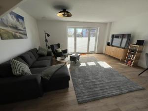 a living room with a couch and a tv at Ferienhaus Ankerplatz in Timmel