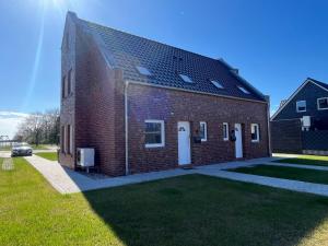 a brick building with a car parked next to it at Ferienhaus Ankerplatz in Timmel