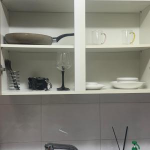 Un estante de cocina con platos y una copa de vino. en 용리단길 제2하우스, en Samgong-ni
