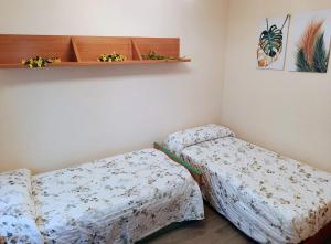 a room with two beds and a shelf on the wall at GR - Polvorín Oasis in Valladolid +7 photos