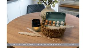a basket of eggs sitting on a table with a vase at Apartment Leinetal - bester Schlafkomfort in hochwertiger Hotelbettwäsche, 3 Zimmer - große Küche, Duschbad & Parkplatz in Northeim +12 photos