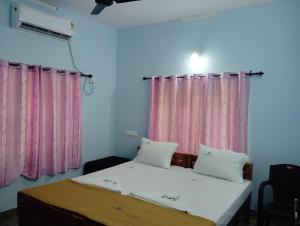 バルカラにあるShalimar Residencyのベッドルーム1室(ベッド2台、ピンクのカーテン付)