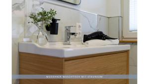 un lavabo con grifo y una plaza en Apartment Leinetal - bester Schlafkomfort in hochwertiger Hotelbettwäsche, 3 Zimmer - große Küche, Duschbad & Parkplatz, en Northeim