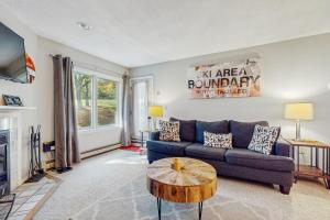 Una sala de estar con un sofá azul y una mesa. en Deer Creek 8A, en West Dover