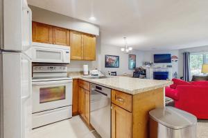 cocina con electrodomésticos blancos y sofá rojo en Deer Creek 8A, en West Dover