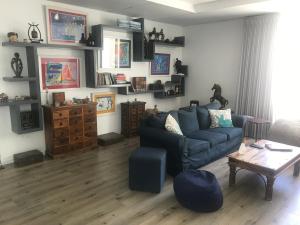 a living room with a blue couch and a table at Luxury Family Home in Helderberg