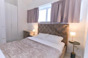 ein Schlafzimmer mit einem großen Bett und einem Fenster in der Unterkunft Apartments Lukas 2 in Zadar