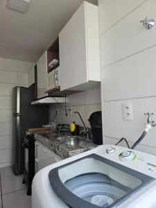 a small kitchen with a sink and a refrigerator at Ap da Familia - SLZ in São Luís