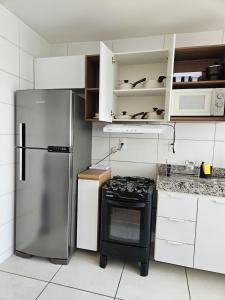 a kitchen with a refrigerator and a stove at Ap da Familia - SLZ in São Luís