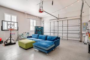 una sala de estar con un sofá azul en un garaje en Pet-Friendly Lakeland Family Oasis with Game Room, en Highland City