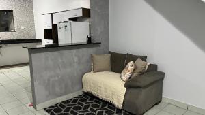 a living room with a chair and a refrigerator at Casa da folha 12 in Marabá
