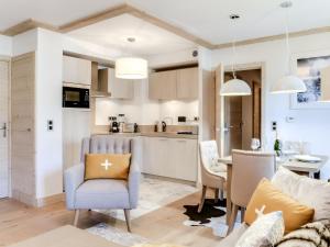 Il comprend une cuisine et un salon avec une chaise bleue. dans l'établissement Appartement moderne avec WiFi et parking sous-terrain à Courchevel Village - FR-1-562-28, à Courchevel