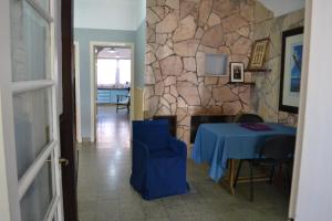Zimmer mit einem blauen Tisch und einer Steinmauer in der Unterkunft Casa Urbana in Villa Progreso