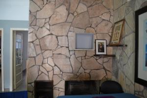 eine Steinmauer mit einem Kamin im Wohnzimmer in der Unterkunft Casa Urbana in Villa Progreso