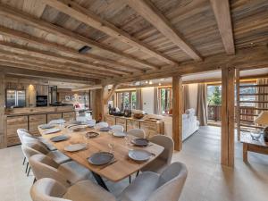 Un comedor con una mesa larga y sillas. en Chalet 5⭐ à Méribel avec Spa, Salle de Sport, Proche des Pistes et Commerces - FR-1-566-62, en Les Allues