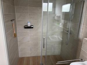 a shower with a glass door in a bathroom at EasyStay in Perl
