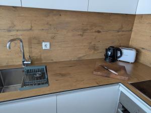 a kitchen counter top with a sink and a knife at Studio Soft Hue in Kosovo Polje