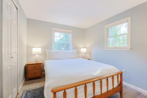 une chambre avec un grand lit et deux fenêtres dans l'établissement Stay On The Cape Vacation Rentals Cape Cod Getaway Near Beaches & Bike Trail, à Eastham 28 autres photos