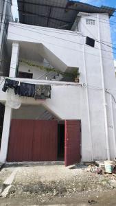 a white building with a red door and a garage at Perfect Stay in Chennai