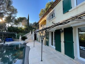 a house with a swimming pool next to a building at Studio GINGKO in Pierrefeu-du-Var