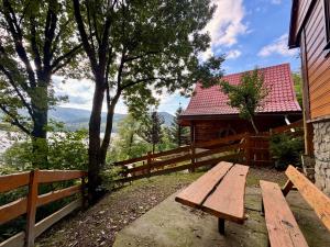 a wooden bench sitting in front of a fence at Drewniany zakątek - domek z sauną i balią in Międzybrodzie Bialskie
