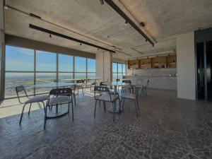 a dining room with tables and chairs and windows at Condomínio Residencial Hype 017 - São José do Rio Pret in Sao Jose do Rio Preto