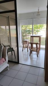 ein Raum mit einem Tisch und zwei Stühlen und einem Fenster in der Unterkunft Studio les pieds dans l'eau belle vue mer in Le Gosier