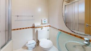 a bathroom with a toilet and a sink at Apartamento T1 Pau da Bandeira in Caliços +41 photos