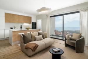 a living room with a couch and a large window at Saraiva Hills II Relaxation in Câmara de Lobos in Panasqueira